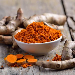fresh turmeric roots on wooden table
