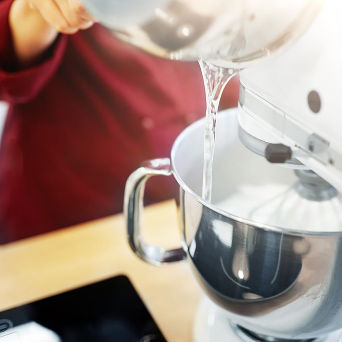 cooking, food and kitchen appliances concept - chef pouring ingredient from pot into electric mixer bowl;