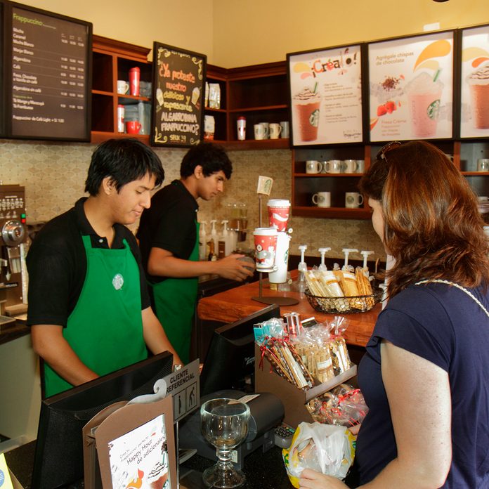 Woman Customer At Counter Ordering Food And Drink In Starbucks Coffee, Avenida Pedro D'osma.