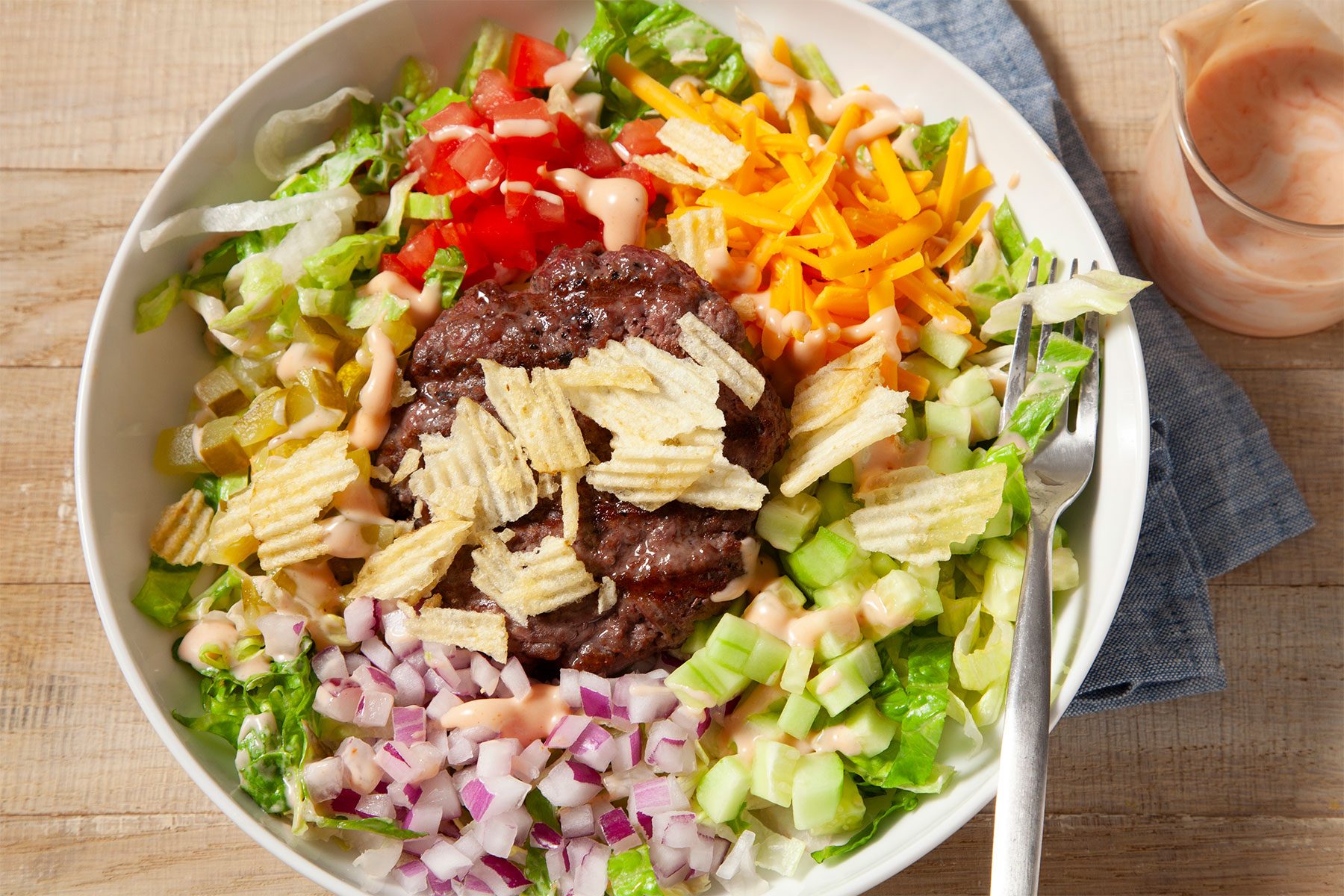 3/4th shot; Cheeseburger Bowl placed over kitchen towel over wooden background;