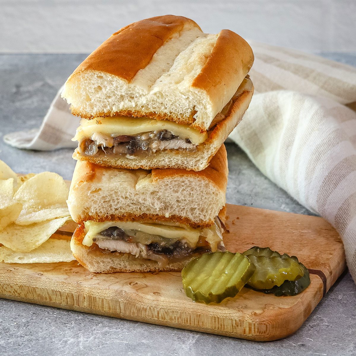 Chicken sub, cut in half, with Swiss cheese, chicken, and mushrooms.
