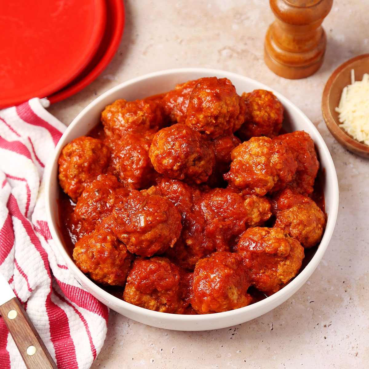 Close up of Taste of Home's Instant Pot Meatballs served in a white serving platter on a brown marble surface.