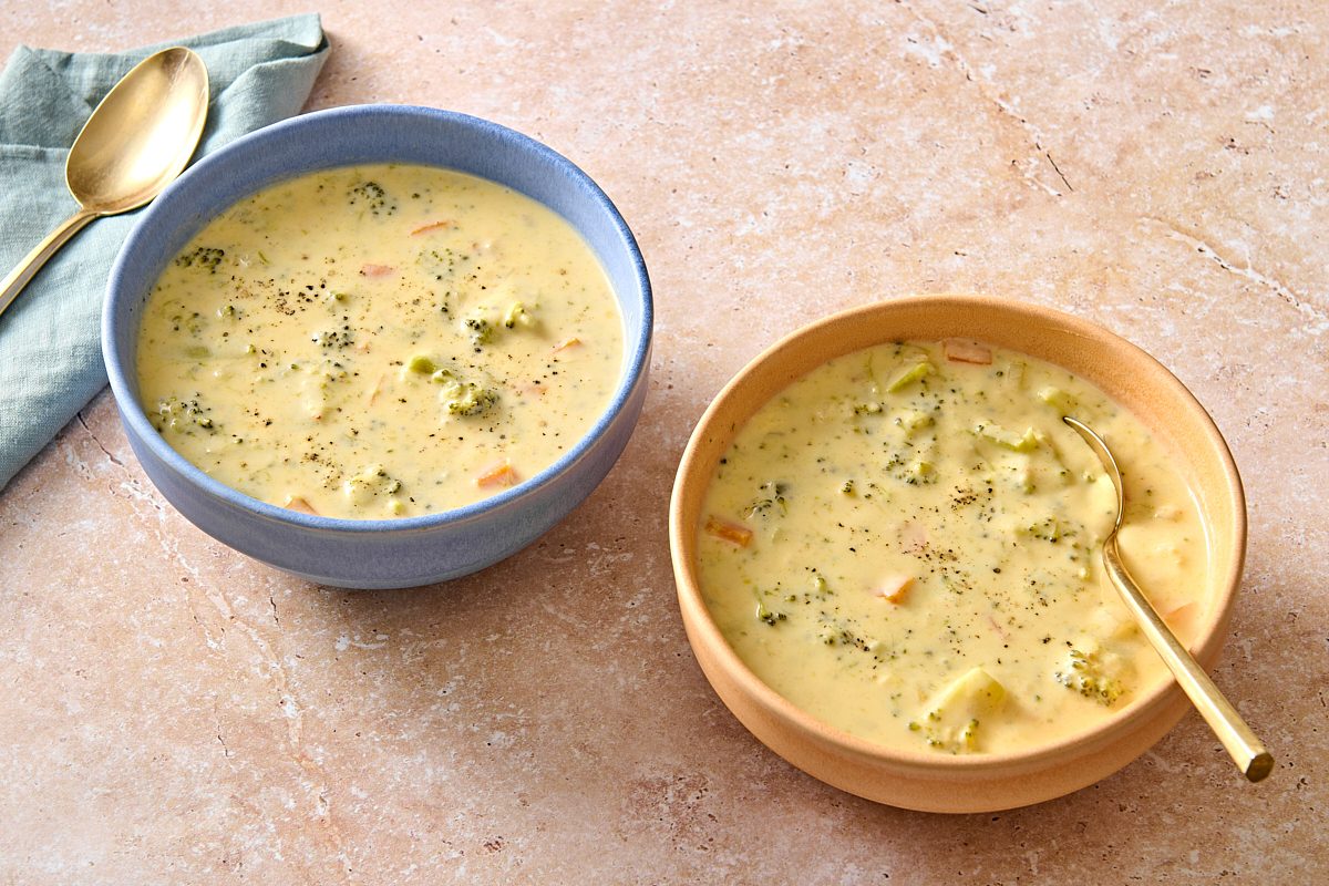 Angled shot of two bowls of Instant Pot broccoli cheddar soup